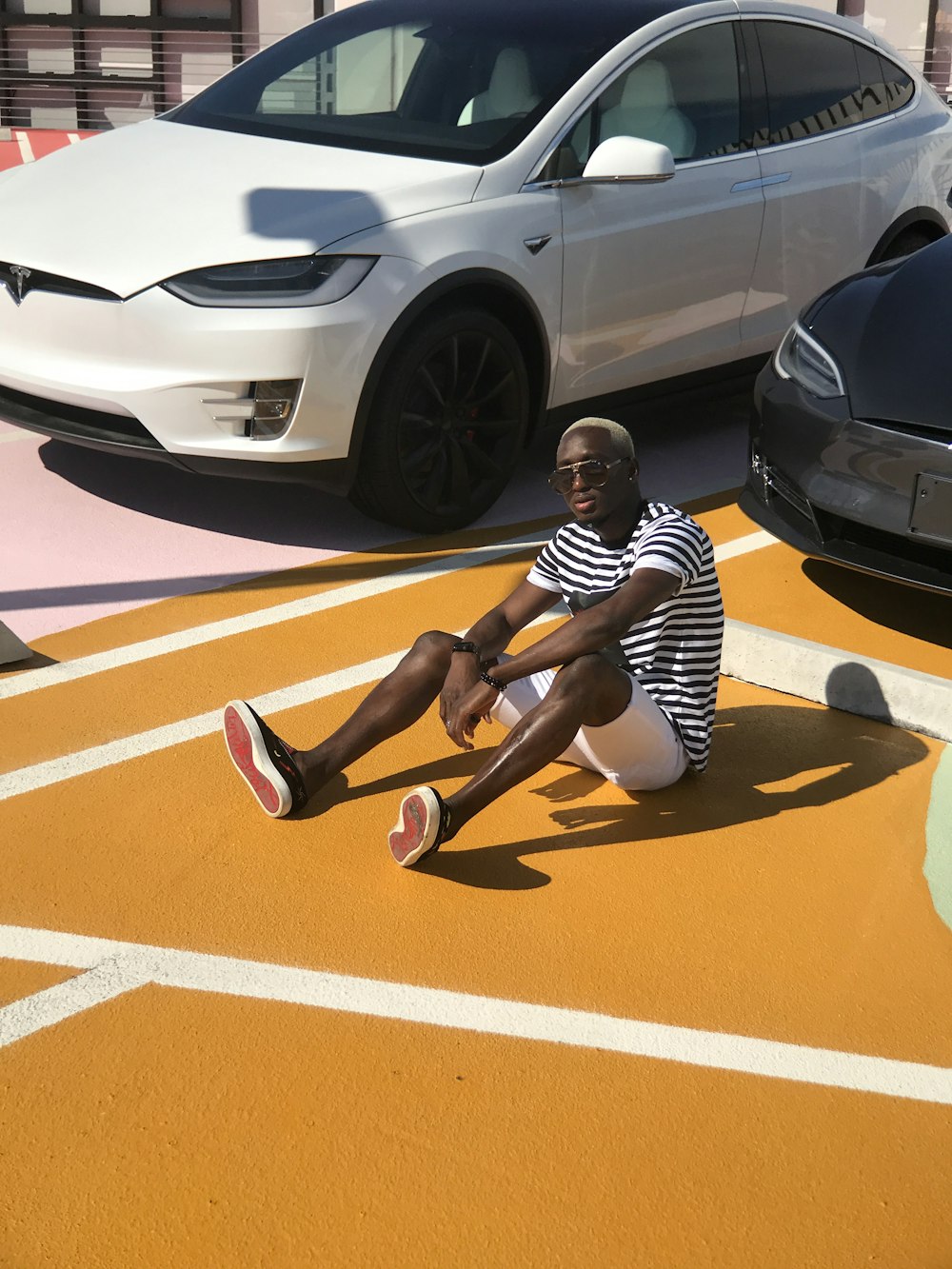 woman in black and white stripe shirt sitting on orange floor