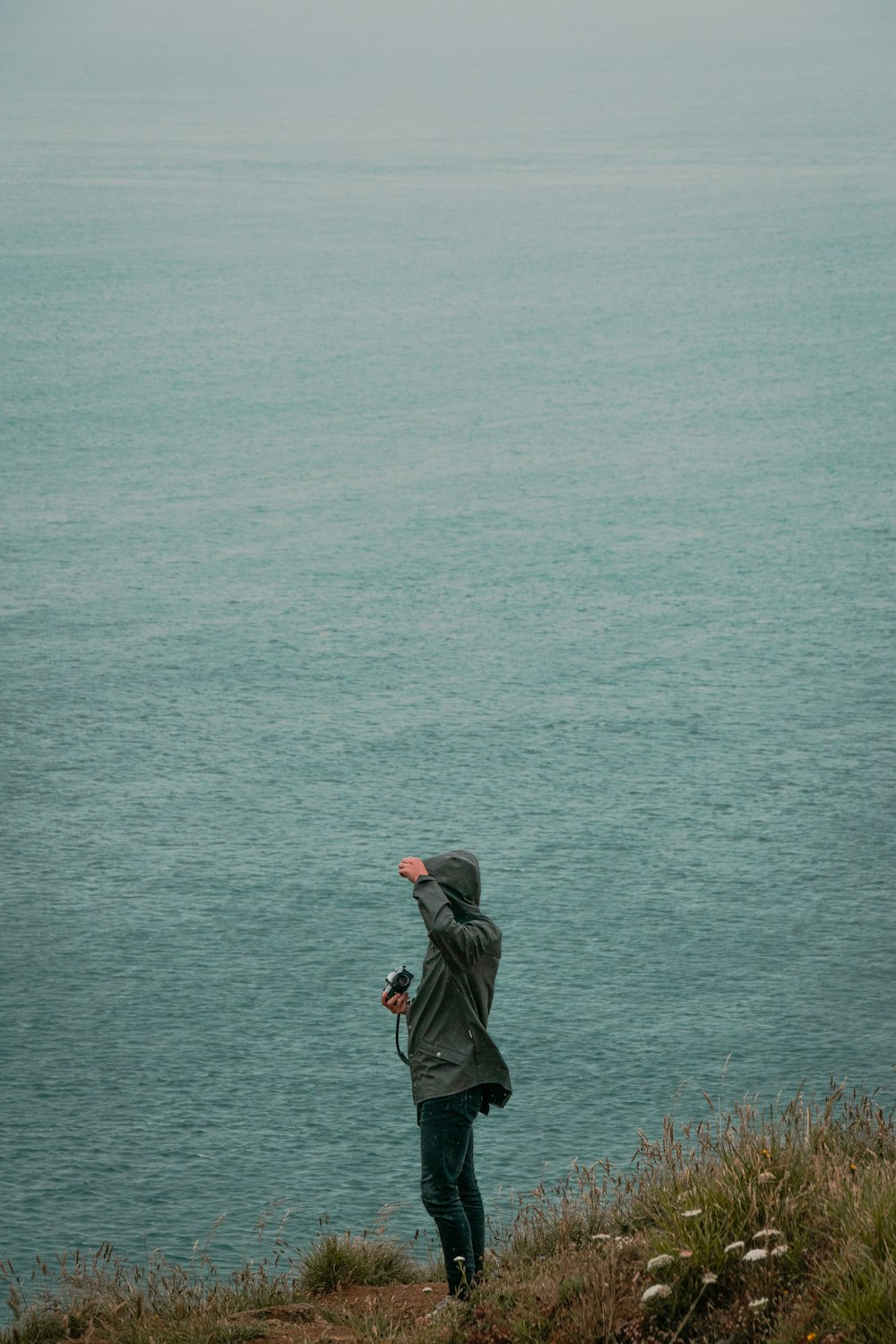 woman in black jacket standing on seashore during daytime