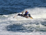 man in blue and red suit riding yellow and black personal watercraft on sea during daytime