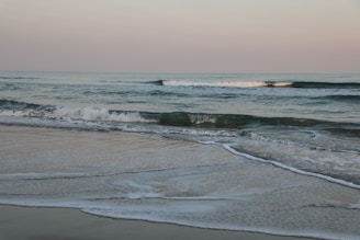ocean waves crashing on shore during daytime