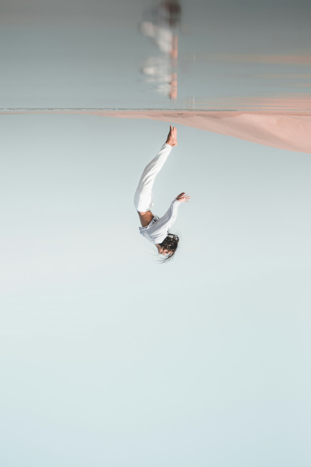 man in white long sleeve shirt and black pants jumping