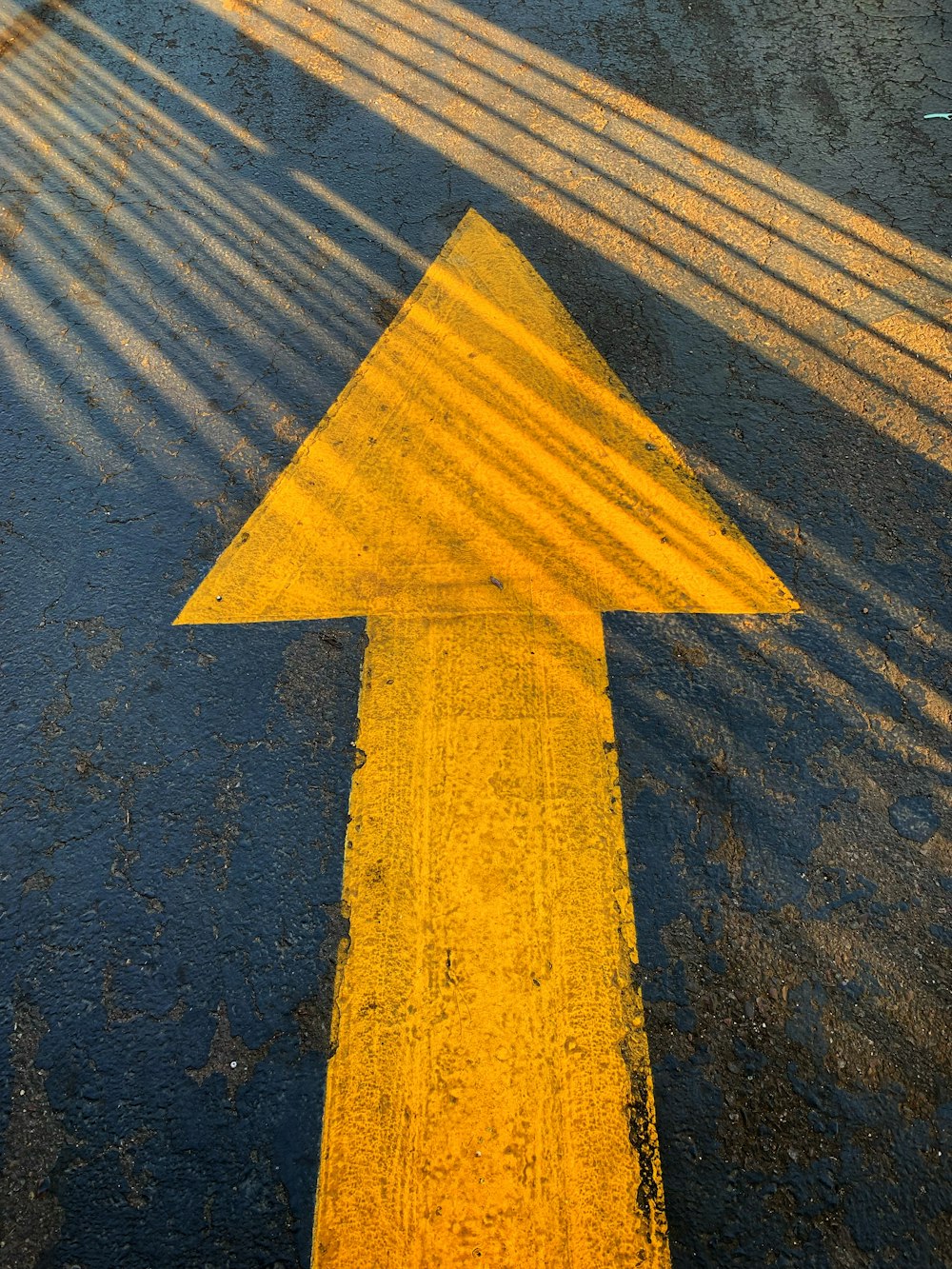 Panneau de flèche jaune sur une route en béton gris