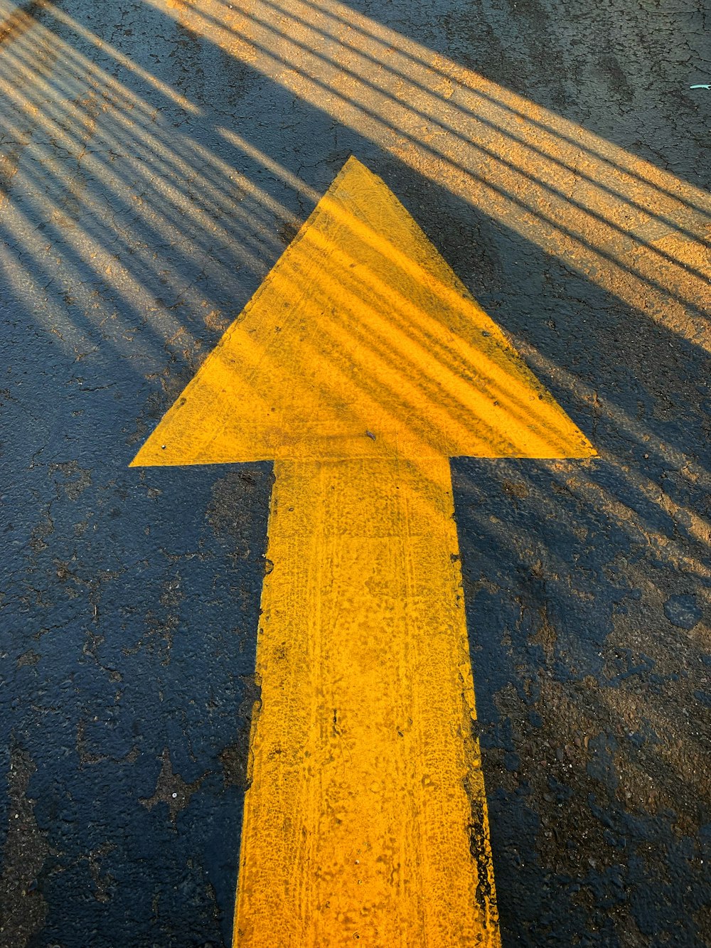 Señal de flecha amarilla en carretera de concreto gris