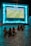 A group of friends joyfully watching a sports game on a large screen.