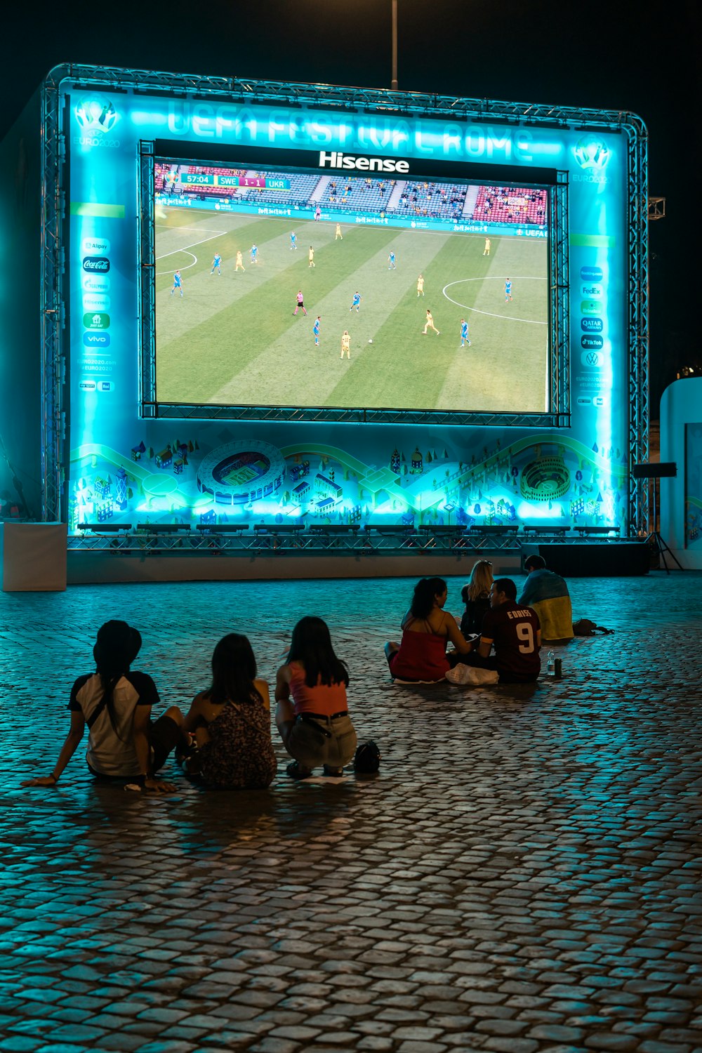 personnes assises par terre devant l’écran du projecteur