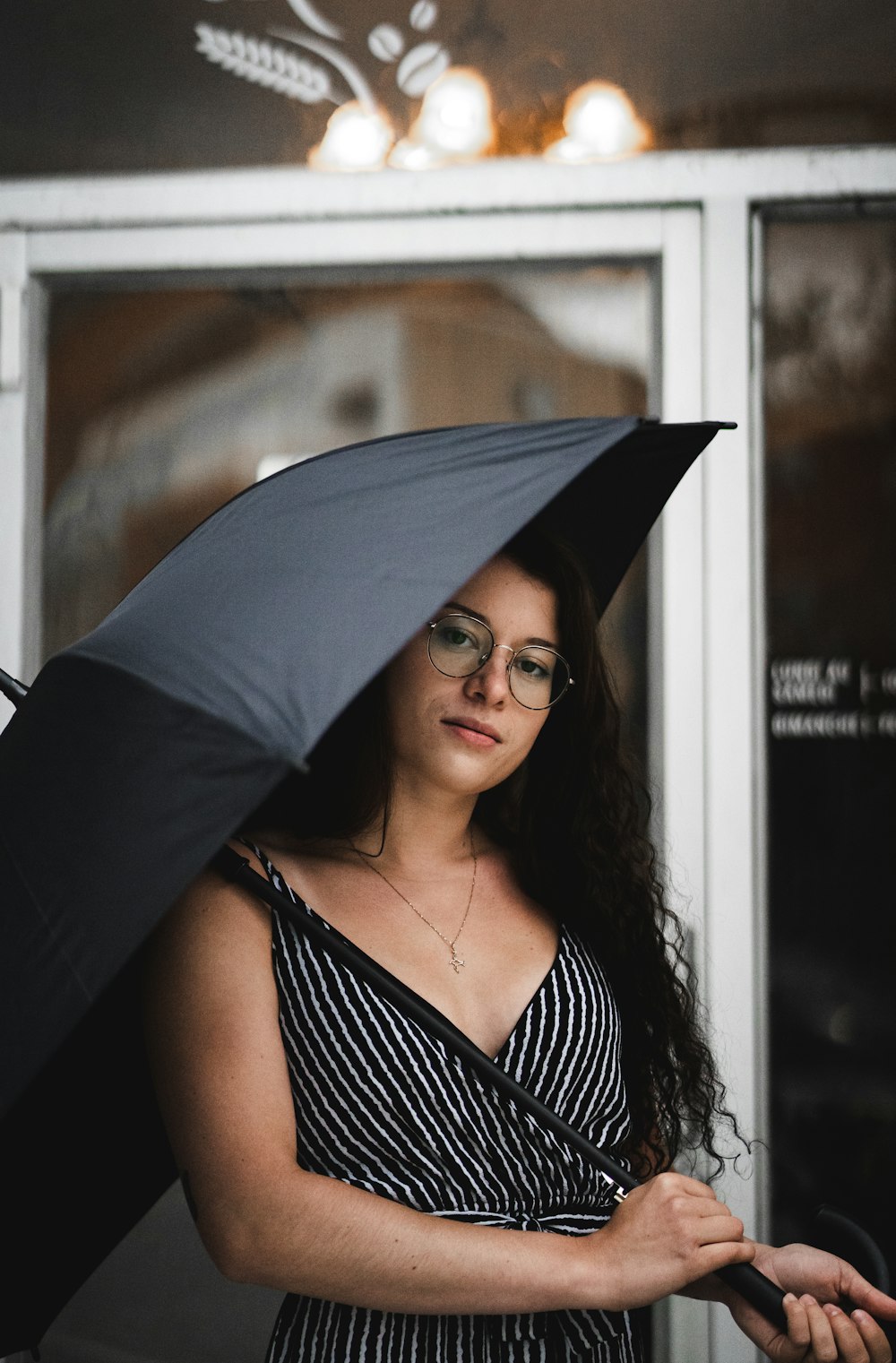 woman in black and white stripe tank top holding umbrella