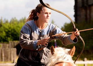 woman in blue and white long sleeve shirt holding brown rope