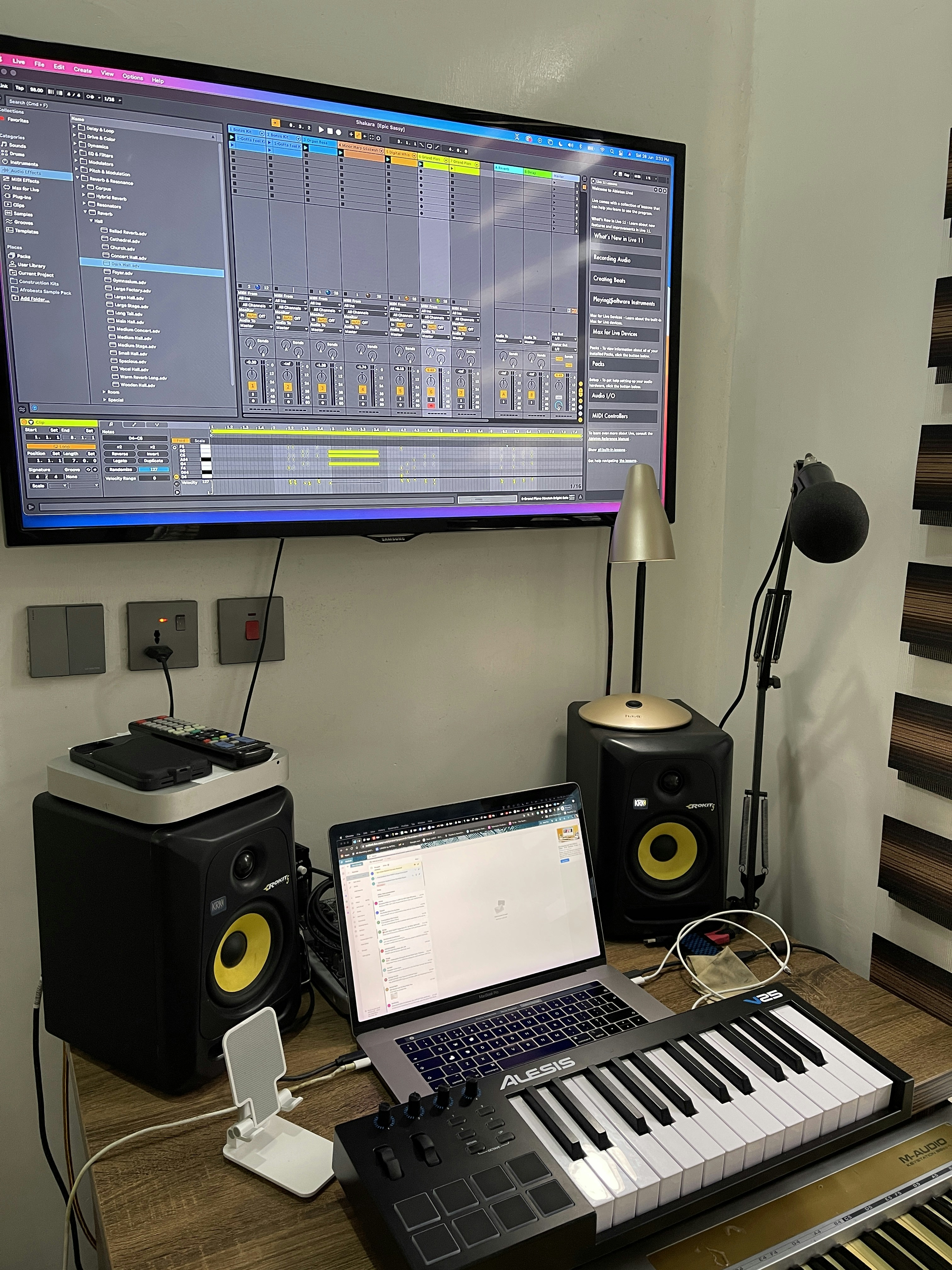 Music production equipment and laptop showing analytics dashboard in studio