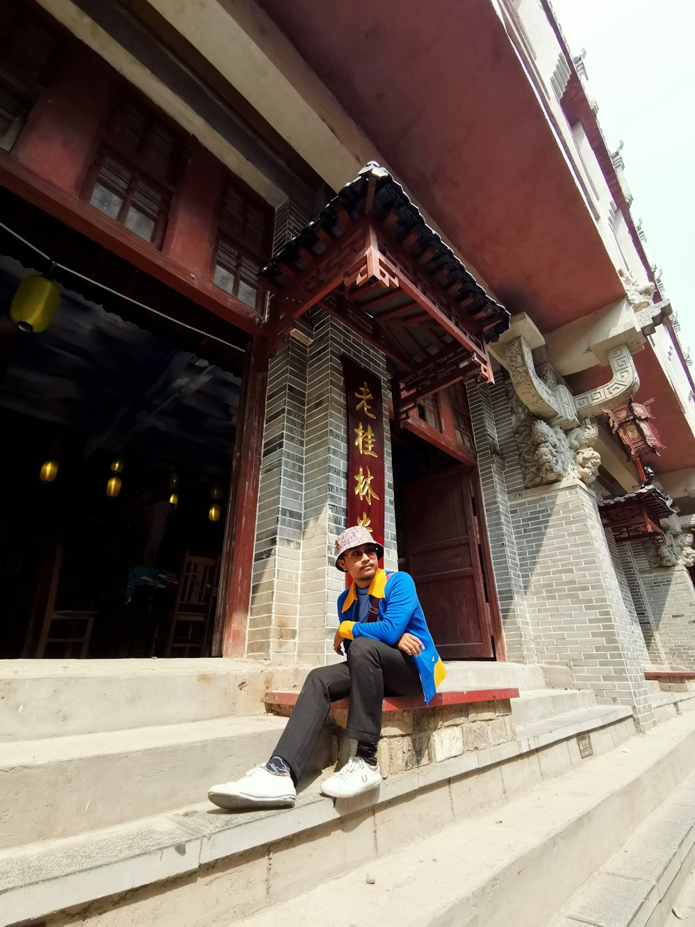 man in blue jacket sitting on white concrete bench