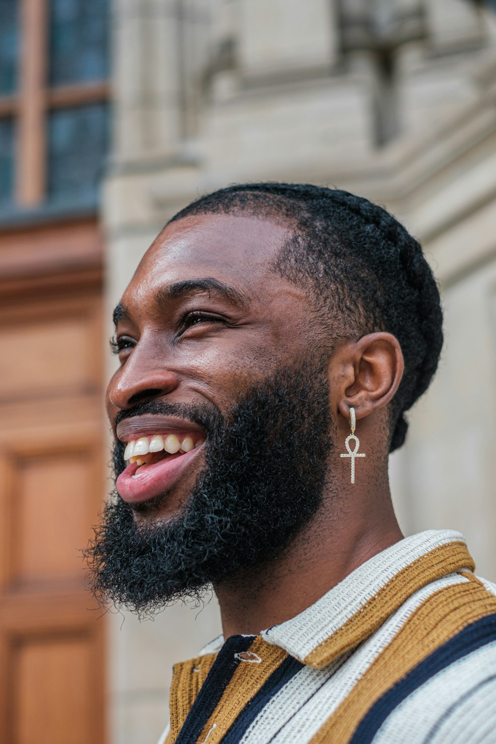 homem na camisa listrada branca e marrom sorrindo