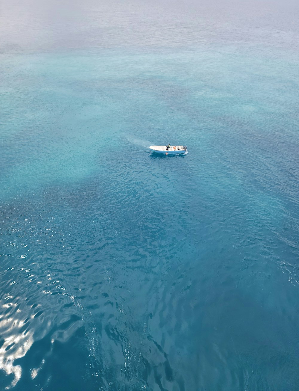 white boat on body of water during daytime