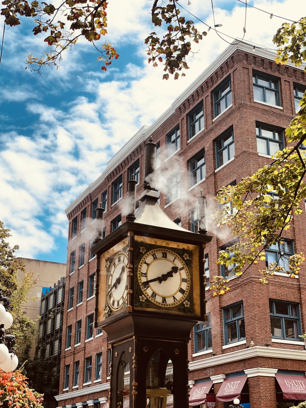 brown and white concrete building with clock under blue sky during daytime