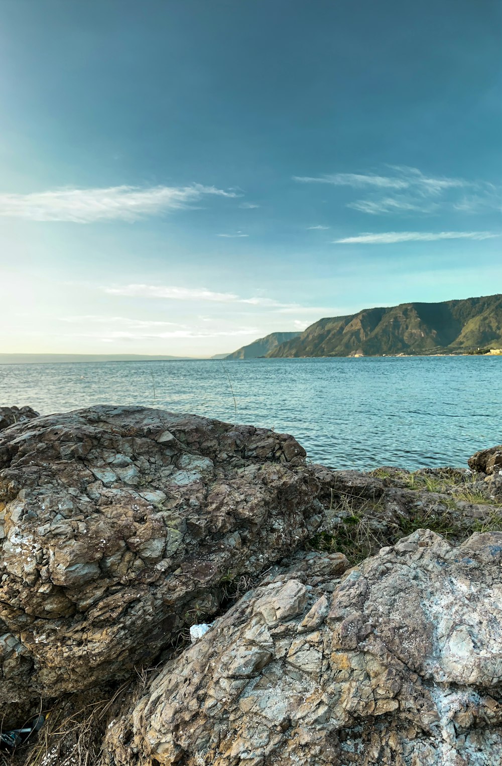 rocky shore with a view of blue sea under blue sky during daytime