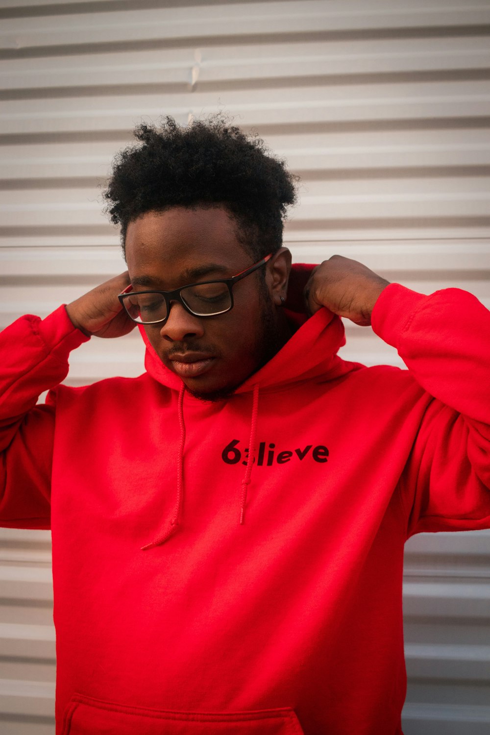 man in red hoodie wearing black framed eyeglasses