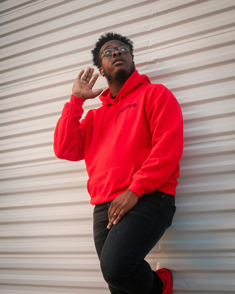 man in red dress shirt and blue denim jeans