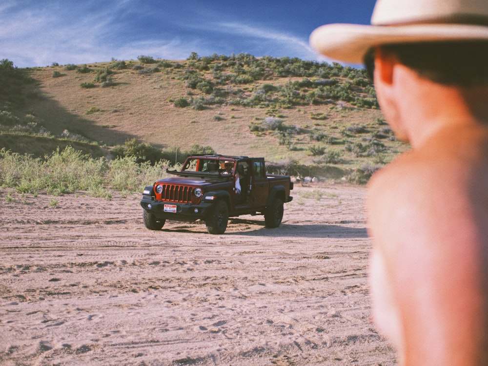 red jeep wrangler on dirt road during daytime