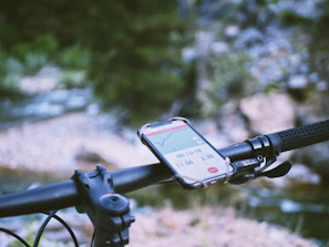 A cyclist’s bike holder attached firmly to the handlebar with a phone displaying navigation