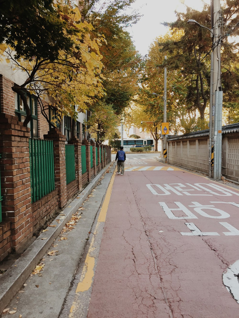 person in black jacket walking on sidewalk during daytime