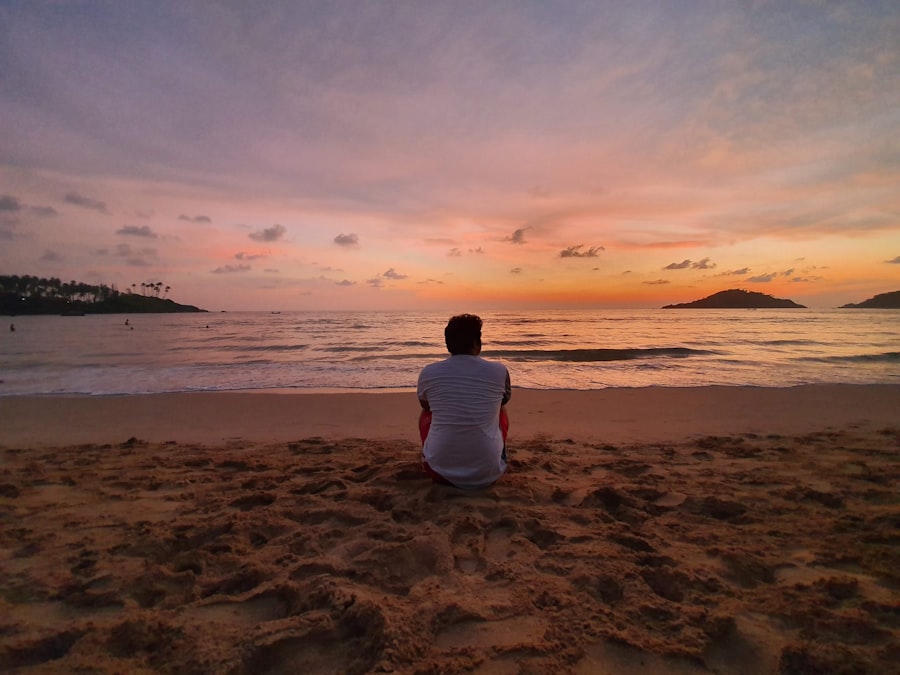 Man relaxing on beach at sunset