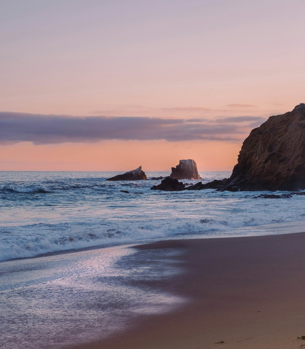 ocean waves crashing on shore during sunset