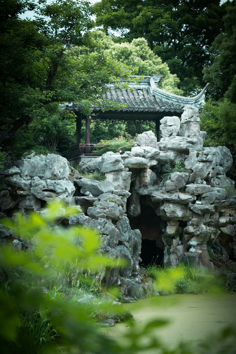 Gazebo de hormigón gris en campo de hierba verde