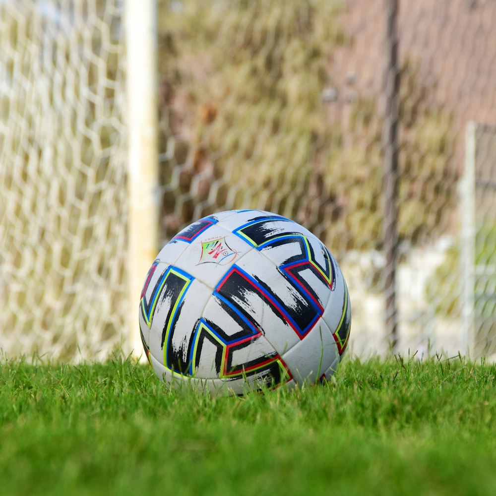 white blue and red soccer ball on green grass field