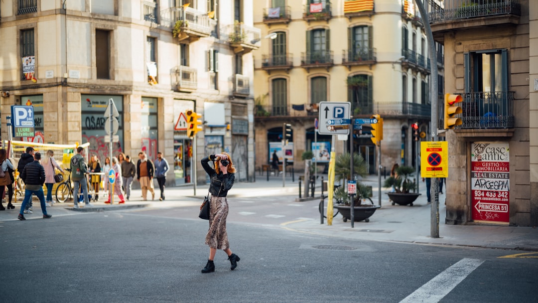 woman in black and white polka dot coat walking on sidewalk during daytime