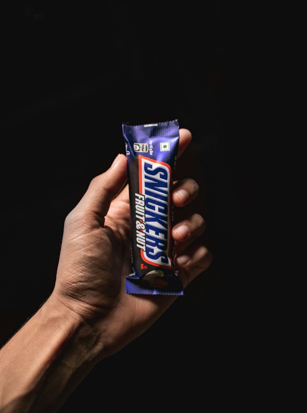 person holding blue and white labeled pack