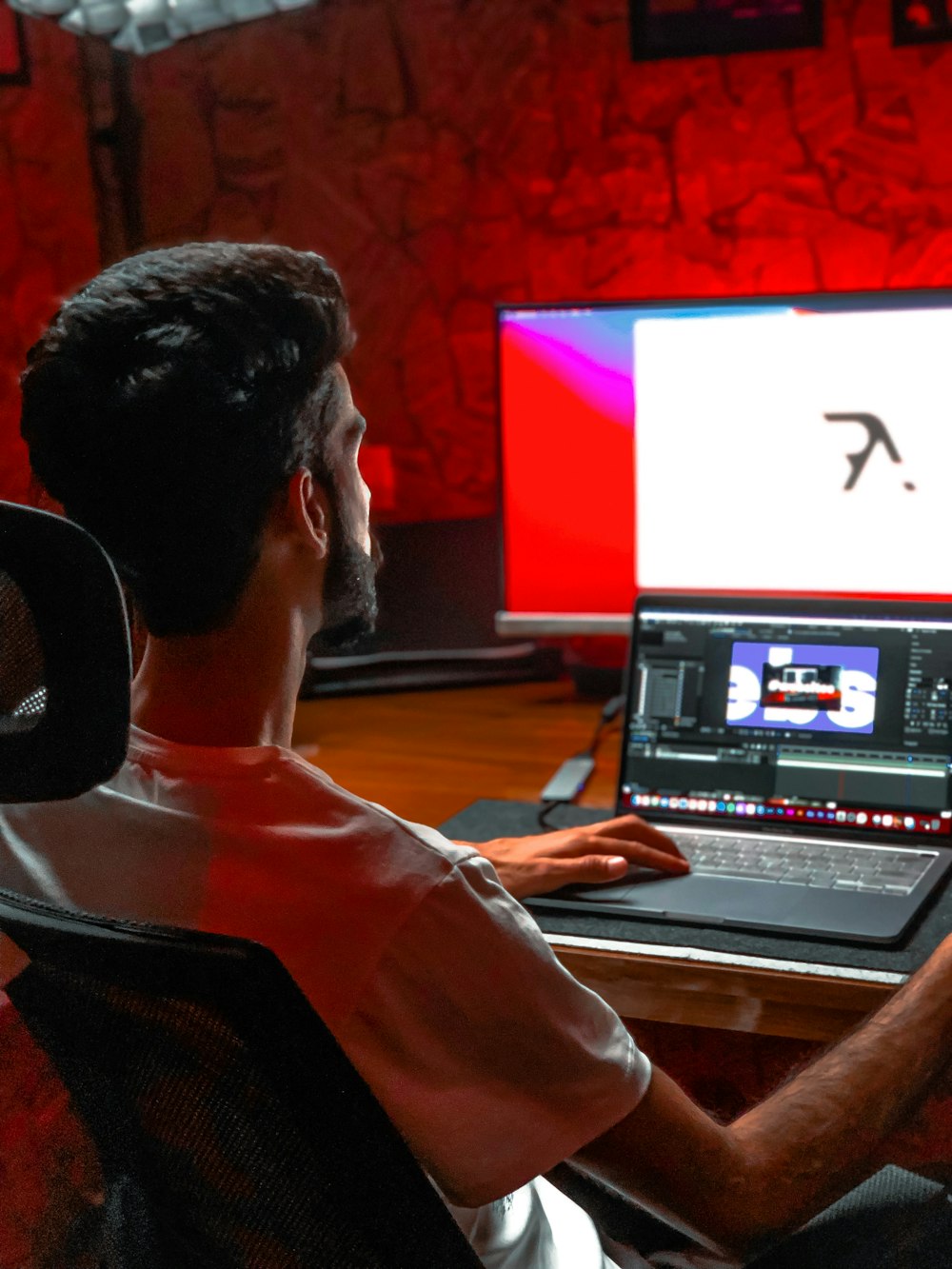 man in white shirt using laptop computer