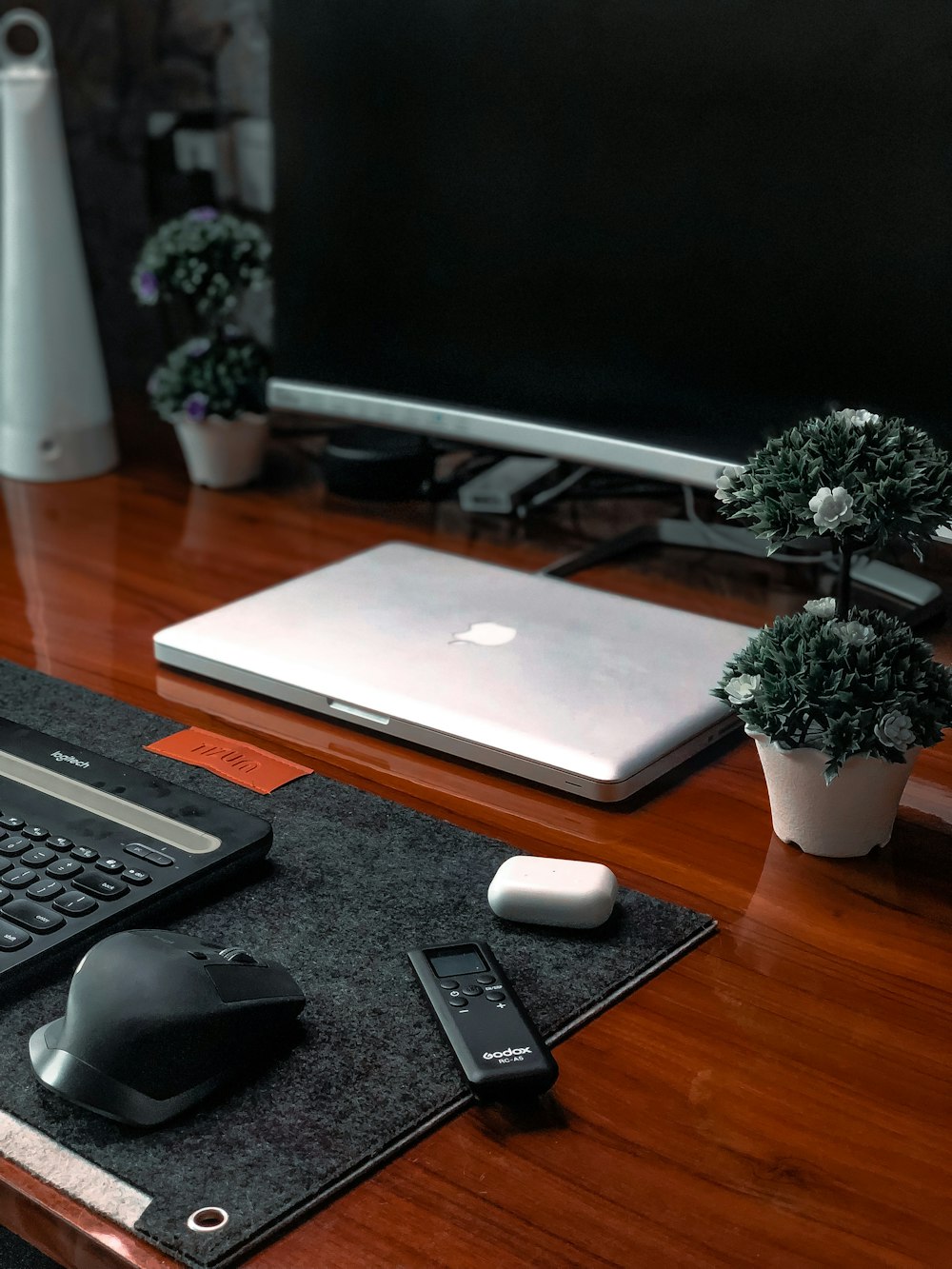 silver macbook beside black computer keyboard on brown wooden table