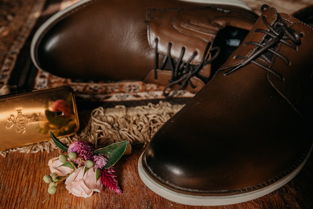 black leather shoe on brown and beige textile