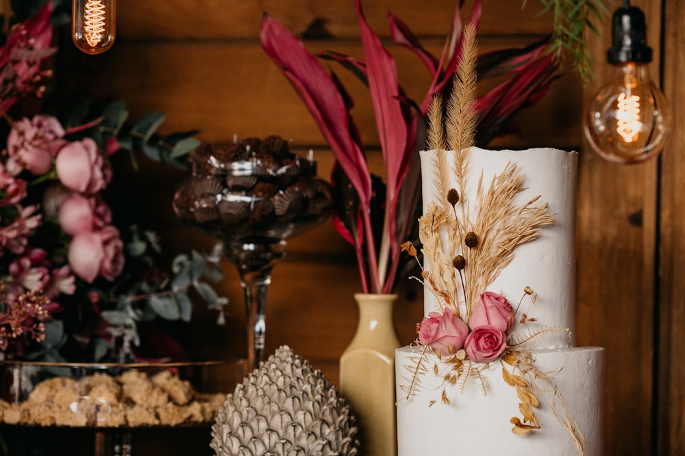 white and pink flower in vase beside clear glass vase