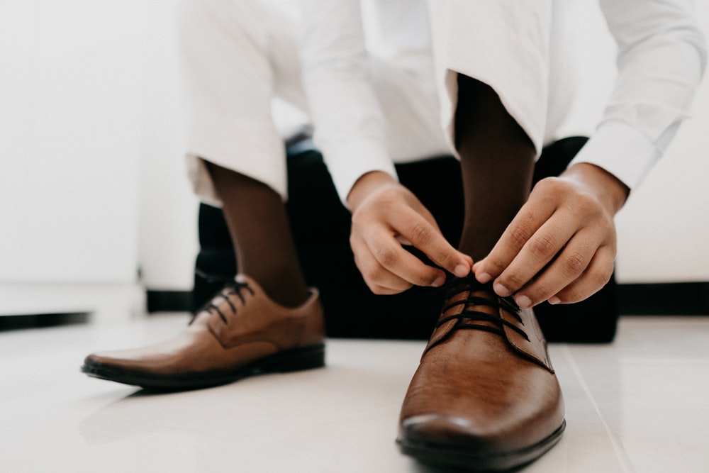 person wearing brown leather shoes