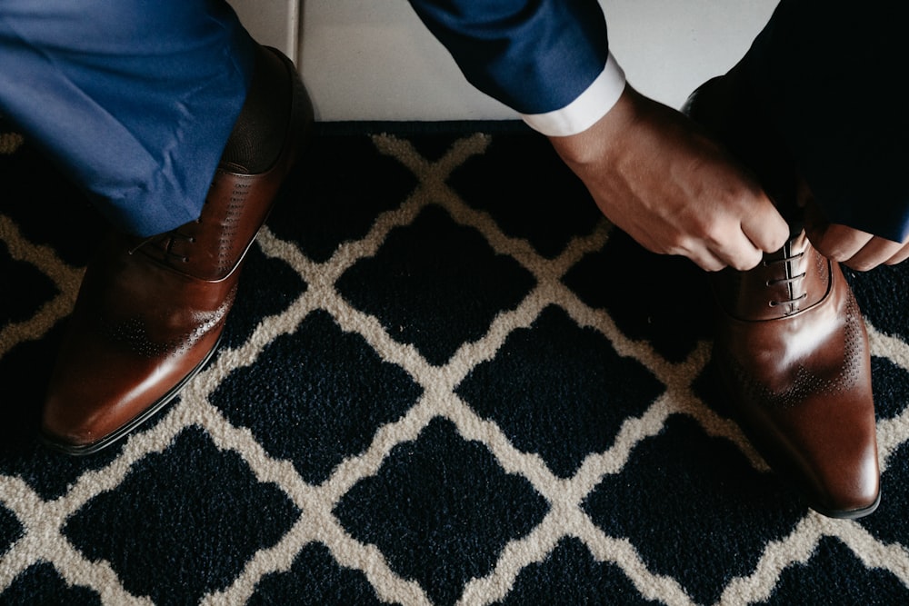 person in blue pants and brown leather shoes