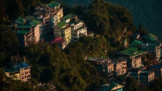 white and red concrete building on green mountain during daytime