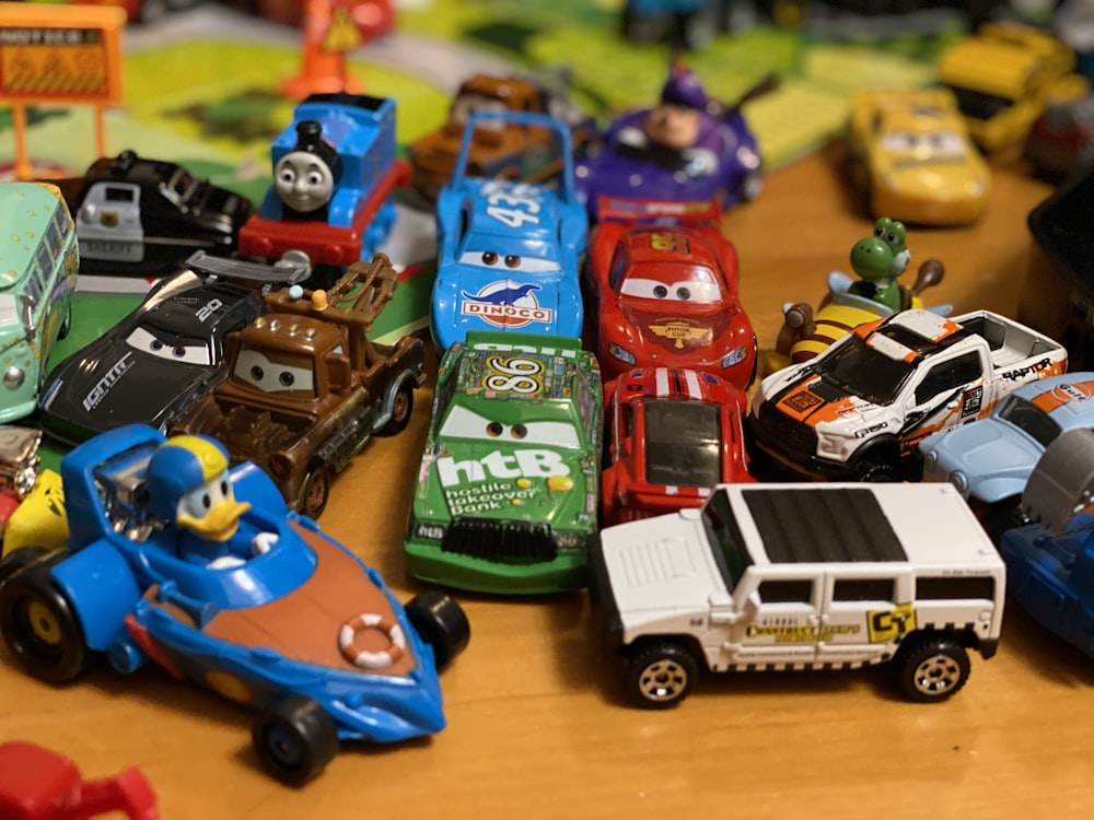 茶色の木製のテーブルにプラスチック製のおもちゃの車を盛り合わせました