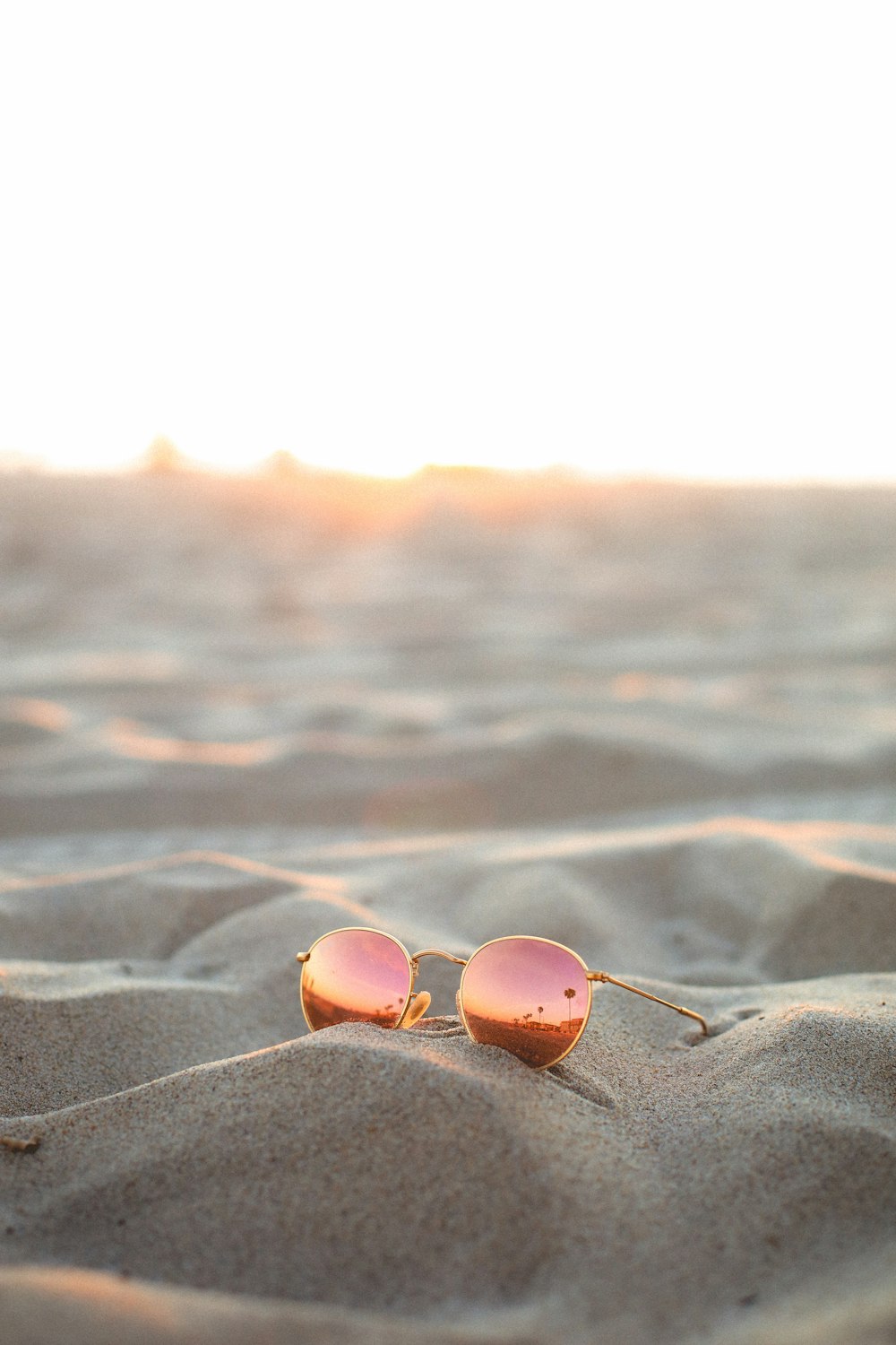 blue and silver framed aviator sunglasses on beach during sunset