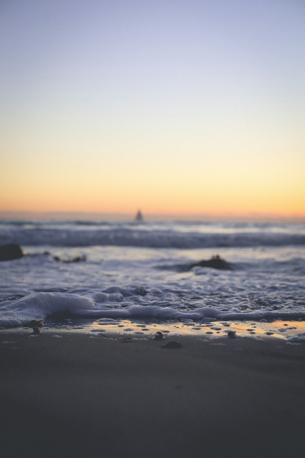 sea waves crashing on shore during sunset