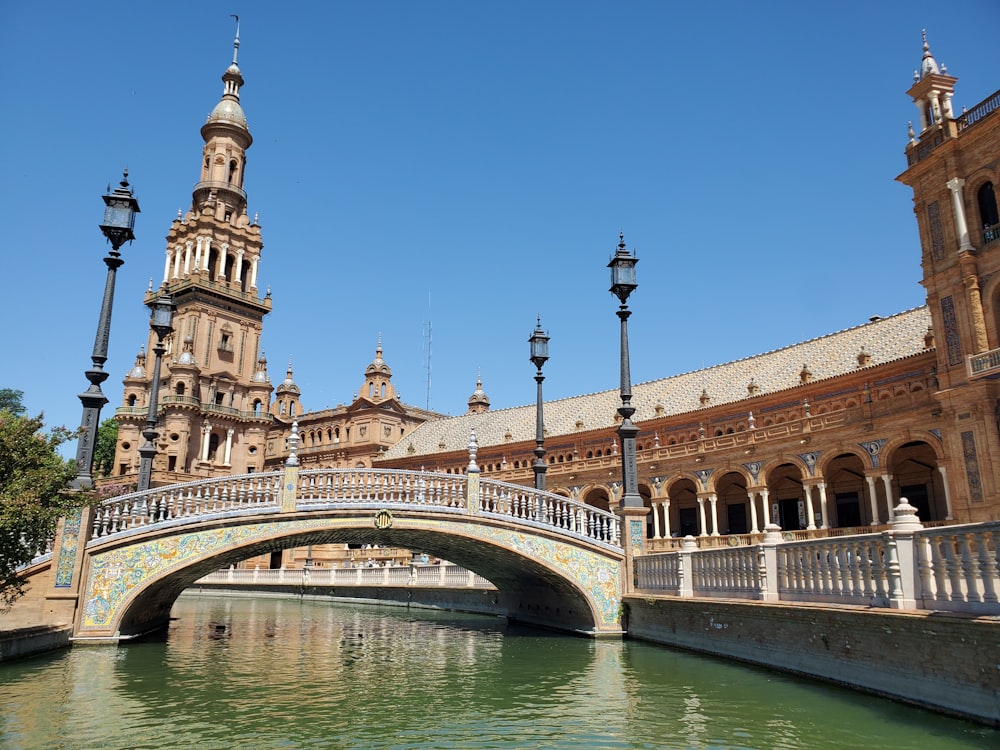 Puente de hormigón marrón sobre el río bajo el cielo azul durante el día