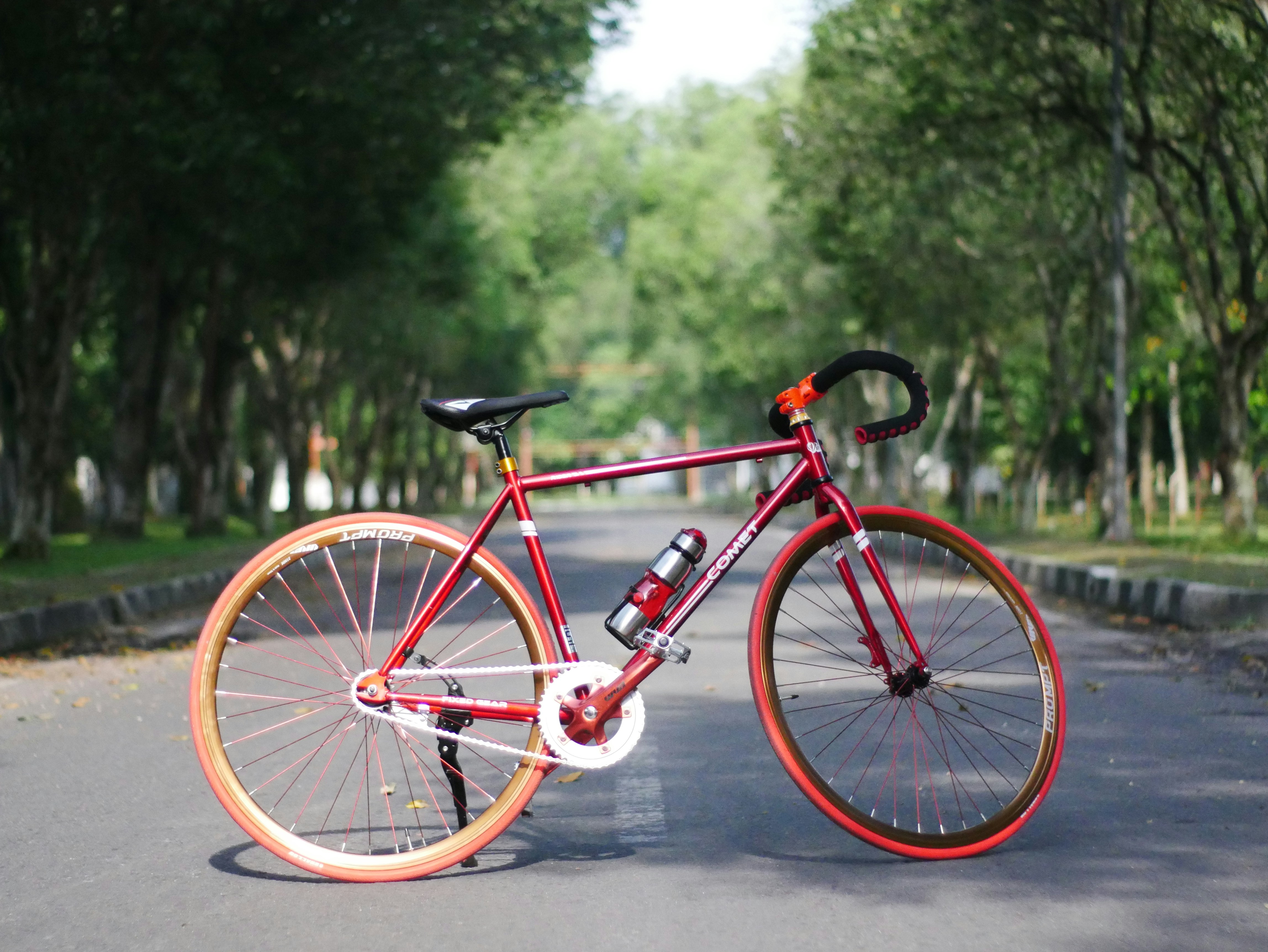 red bicycle on road during daytime