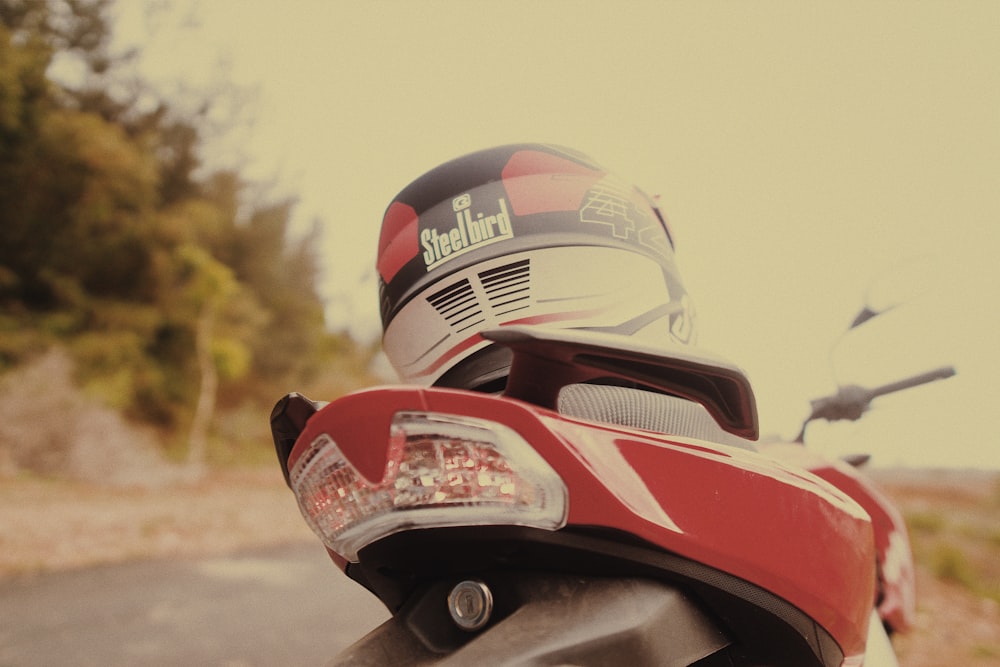 person wearing red and black helmet riding red motorcycle