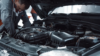 Auto service center mechanic working on a vehicle engine
