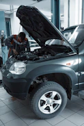 man in black jacket standing beside black car