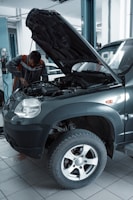 man in black jacket standing beside black car
