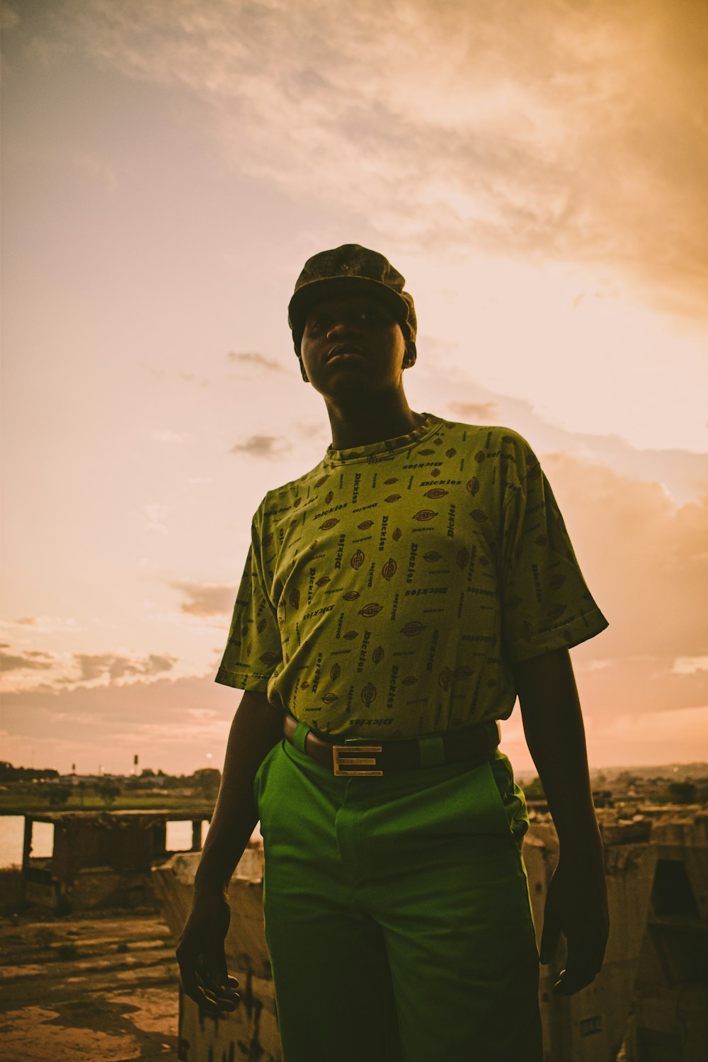 man in green and black crew neck t-shirt standing near body of water during daytime