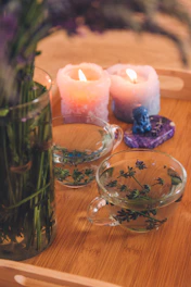 Delicate candles and small decorative vases arranged on a wooden tabletop.