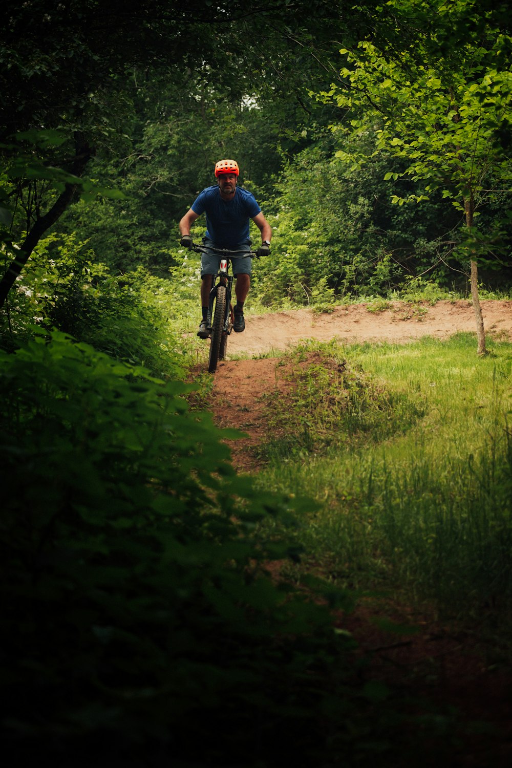 Hombre con camisa azul montando en bicicleta en el campo de hierba verde durante el día