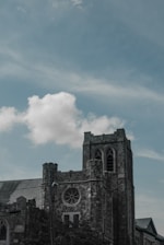 gray concrete building under white clouds and blue sky during daytime