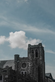 gray concrete building under white clouds and blue sky during daytime