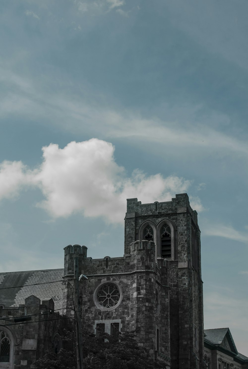 gray concrete building under white clouds and blue sky during daytime